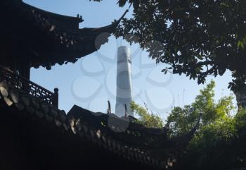 Detail of roof carvings with modern tower block in Yuyuan Garden in  the old city of Shanghai