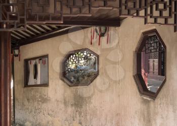 Window into small courtyard with tree planting in Yu or Yuyuan Garden in  the old city of Shanghai