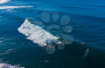 Surfers waiting for the big wave in the sea at Banzai Pipeline on north coast of Oahu, Hawaii