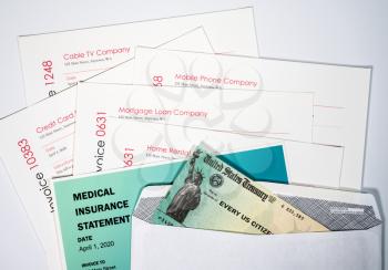 Goverment check in envelope to illustrate coronavirus stimulus payment being used to pay many past due bills and invoices