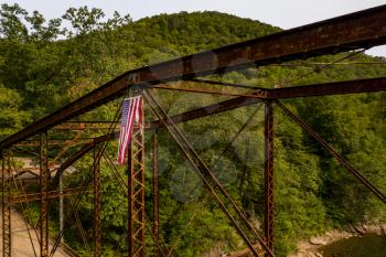 Aerial view of torn damaged Stars and Stripes flag on the historic metal truss Jenkinsburg Bridge near Morgantown