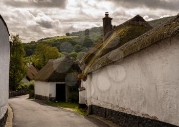 Stone homes and thatched roofs on small lane in the pretty Devon village of Dunsford