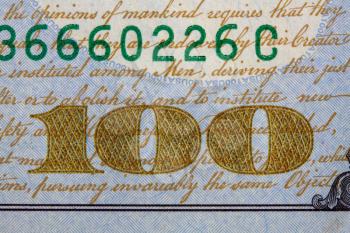 close up image of 100 denomination on a hundred dollar bill of the United States of America