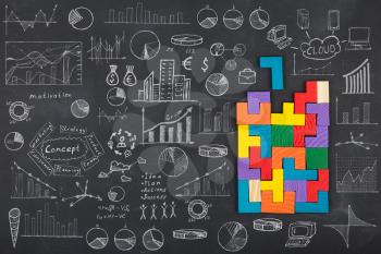 Business concept - jigsaw, sketch with schemes and graphs on chalkboard