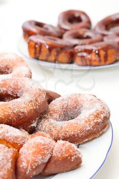 Sweet donuts on the plate with sugar and chocolate glaze.