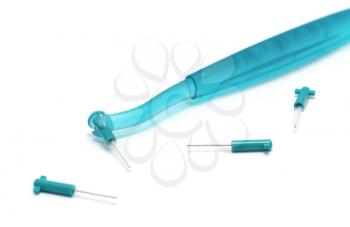 Interdental brush with spare brushes on a white background.