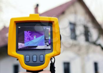 Recording Heat Loss of the Roof on the House with Infrared Thermal Camera in Hand. 