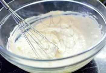 Cheese with whisk in glass bowl. Preparing of sweet cake. Whisking the cheese.