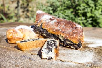 Strudel with poppy seeds on a Wooden Table All Sprinkled With Sugar Powder