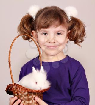 little girl holding a basket with dwarf white bunny