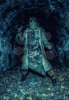 Survived in nuclear disaster and living in catacombs or city underground tunnels human creature, wearing rags and handmade lamellar body armor, hiding face behind mask, armed with pistol and machete