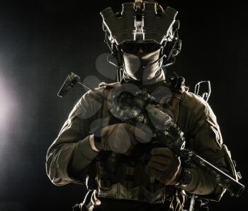 Elite commando fighter, private military company mercenary, special operations serviceman, security or secret service shooter equipped modern weapons and ammunition, studio shoot on black background