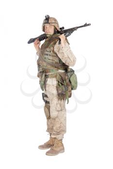 Studio shoot of army, marine machine gunner in camouflage combat uniform and body armor, standing with machine gun, isolated on white