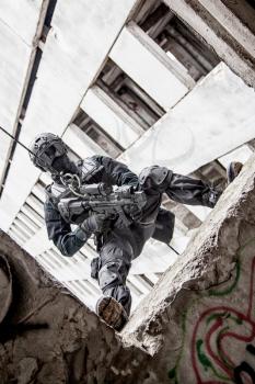 Spec ops police officer SWAT during rope exercises with weapons