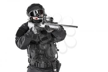 Studio shot of swat operator with sniper rifle wearing black uniforms pointing enemy. Tactical helmet gloves, eyewear and telescopic sight