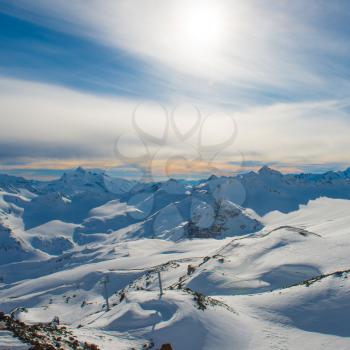 Snowy blue mountains in clouds. Winter ski resort