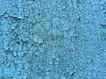 Old cracked paint pattern on wall. Peeling paint. Pattern of rustic blue grunge material. Damaged paint. Wall covered with cracked paint. Flaking paint on a concrete wall. Scratched old surface.