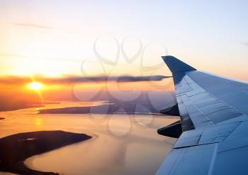 View of the sunset from the airplane porthole. The view from the window of a passenger plane during the flight
