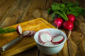 Slices of fresh radish on the used chopping board, copy space