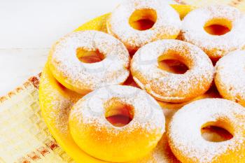 Icing homemade donuts on yellow plate. Sweet dessert pastry doughnuts. Hanukkah sweet donuts.