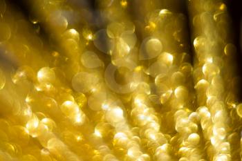 Festive background with defocused golden glitters, bokeh effect.