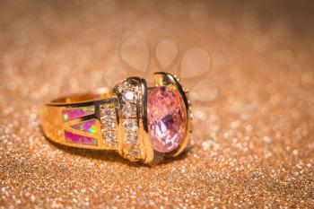 Rose gold ring decorated with pink zircon and fake opal.