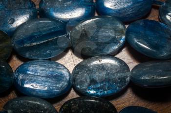 Natural blue kyanite stone, oval shape beads background.