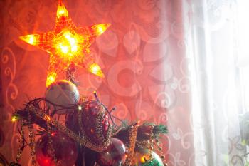 Close up of Christmas or New Year fir tree with decorative lights and toys.