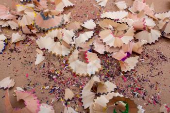 Colorful pencil shavings on a brown background