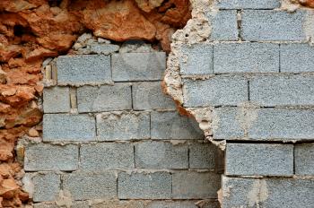 Broken stone and cinder block brick walls background texture.
