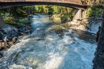 The Tumwater Rvier rushes beneath a walking bridge.