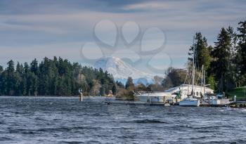 A boat is moored along Lake Washington with Mount Rainier in the distance.
