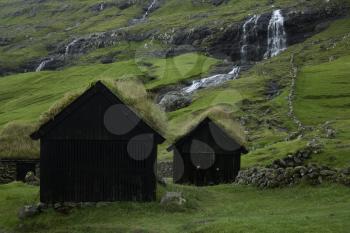 Saksun, Faroe Island - 18 September: Typical hut with grass roof and waterfall