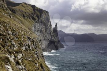Trollkonufingur rock, also called The Witch's Finger on the island of Vagar. Trollkonufingur is a freestanding sea stack rock on the east of Sandavagur village on the Faroe Islands