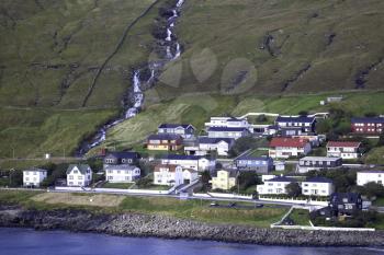 View of Sandavagur village and tvatta waterfall across the fjord, Faroe Islands
