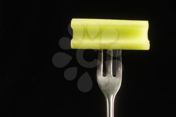 Celery on a fork on a black background