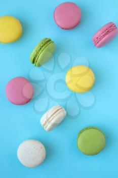 Top view of colorful french traditional macarons on blue background