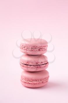 Stack of french tradional pink macarons on pink background