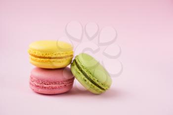 Pink, yellow and green macaroons on pink background