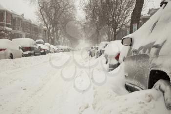 Car covered of snow and parked in a street during a snowstorm in Montreal in  Canada