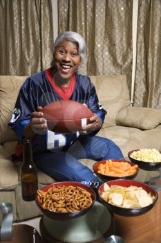 Royalty Free Photo of a Smiling Middle-aged African-American Woman Wearing a Jersey and Holding a Football