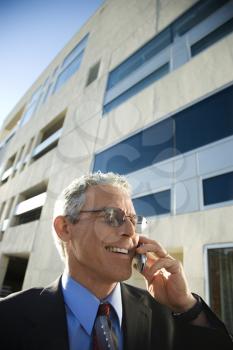 Royalty Free Photo of a Businessman Smiling and Talking on a Cellphone in an Urban Setting