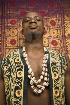 Royalty Free Photo of a Portrait of an African American Man Wearing an Embroidered African vest and Beads