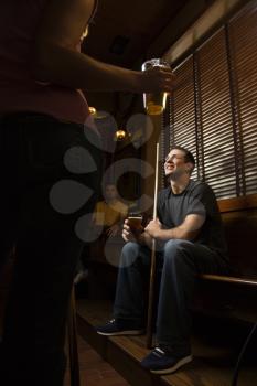 Royalty Free Photo of a Young Man Holding a Billiards Cue While Hanging Out at a Pub