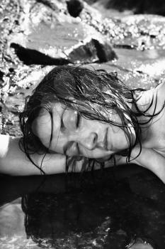 Royalty Free Photo of a Close-up of a Nude Woman Lying in Water at Maui Coast With Her Head Resting on Her Arm