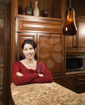 Royalty Free Photo of a Woman Leaning on a Marble Kitchen Counter Smiling 