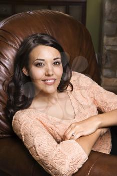 Royalty Free Photo of a Young Woman Sitting in a Leather Chair Smiling