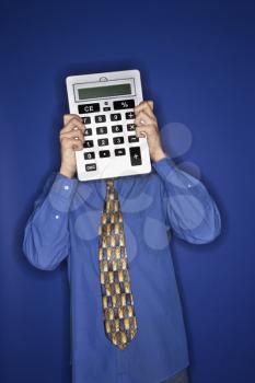Royalty Free Photo of a Teen Boy Holding a Big Calculator in Front of His Face