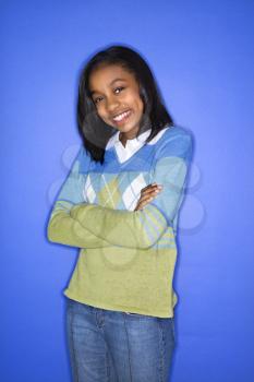 Royalty Free Photo of a Portrait of a Teen Girl With Arms Crossed Standing Smiling