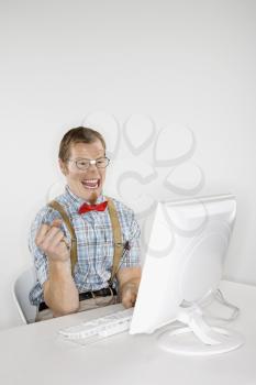 Royalty Free Photo of a Man Dressed Like a Nerd Smiling at a Computer
